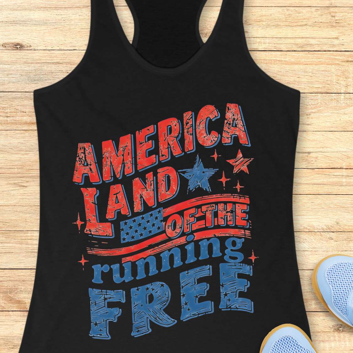 Black tank top with 'America Land of the Running Free' text design on a wooden surface.
