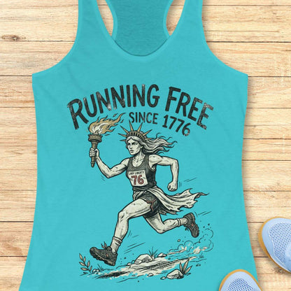 blue tank top with a design of lady liberty running and text - 'running free since 1776', on a wooden surface.