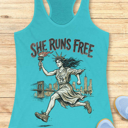 blue tank top with a design of lady liberty running and text - 'she runs free NYC', on a wooden surface.