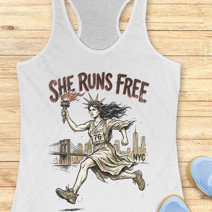 white tank top with a design of lady liberty running and text - 'she runs free NYC', on a wooden surface.