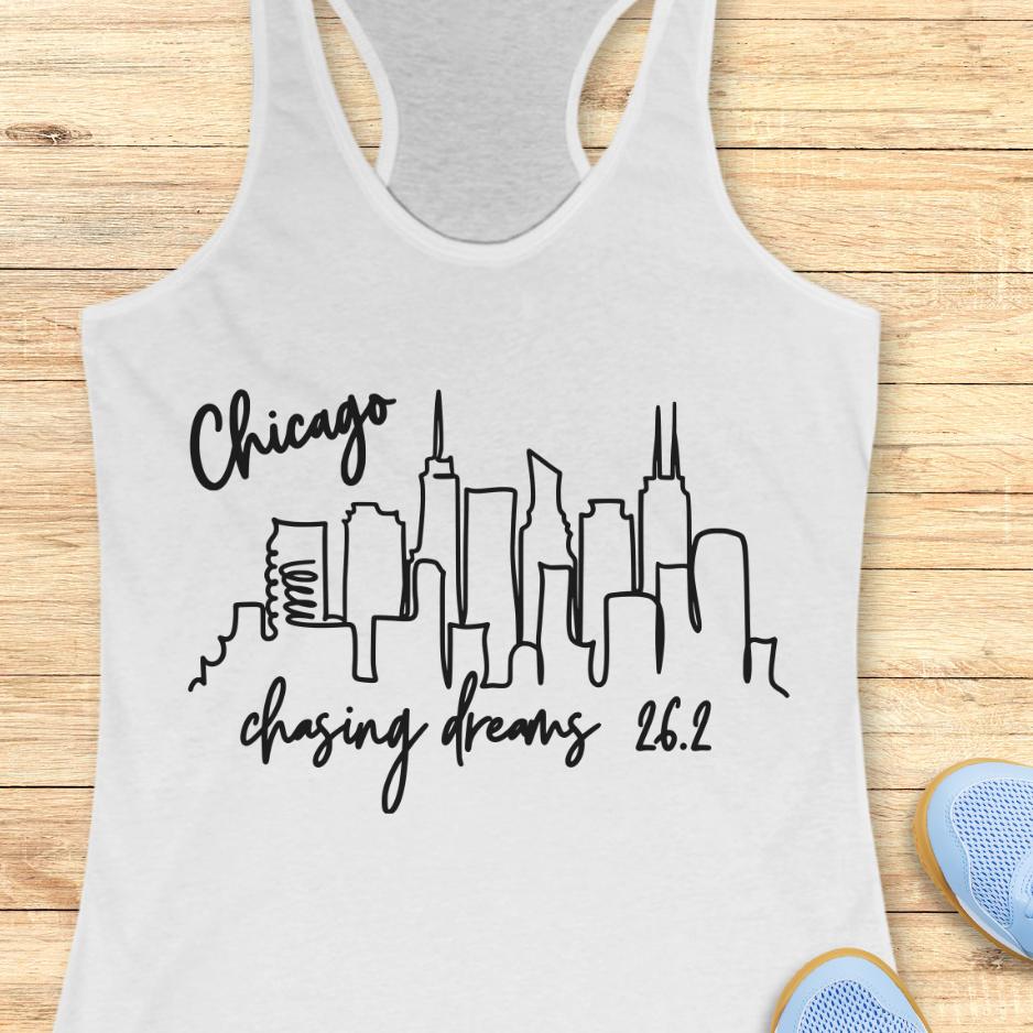 white tank top with the text- Chicago, chasing dreams 26.2, with an image of Chicago skyline. on a wooden background