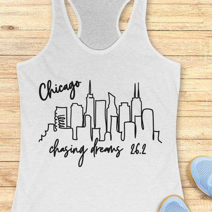 white tank top with the text- Chicago, chasing dreams 26.2, with an image of Chicago skyline. on a wooden background
