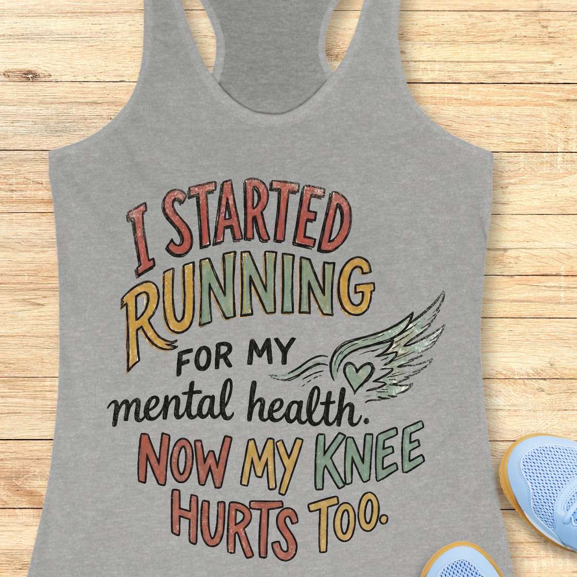 Gray tank top with motivational quote on a wooden surface