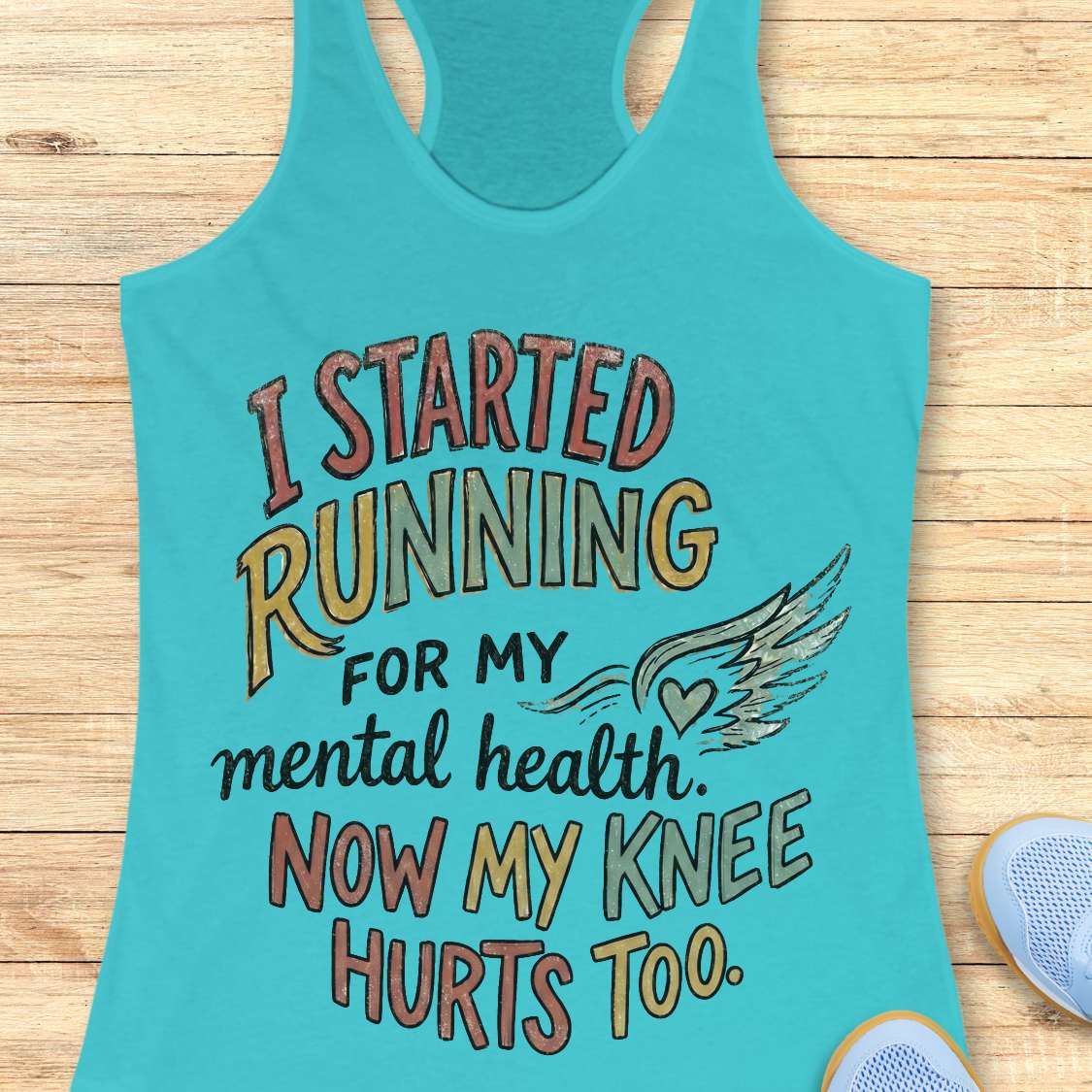Turquoise tank top with humorous running text on a wooden surface