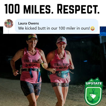 Photograph of two smiling women in pink "Feral Runner Do Not Pet" tank tops and a headlamp running at night during a 100-mile ultramarathon, with "100 MILES. RESPECT." and a Laura Owens comment text overlays, and an Upstate Race Series logo with a South Carolina outline