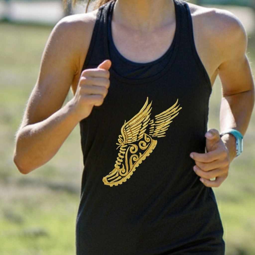 Photograph of a female runner wearing a black tank top with a striking gold winged running shoe emblem featuring ornate scrollwork, actively training in an outdoor setting with a light blue athletic watch on her right wrist