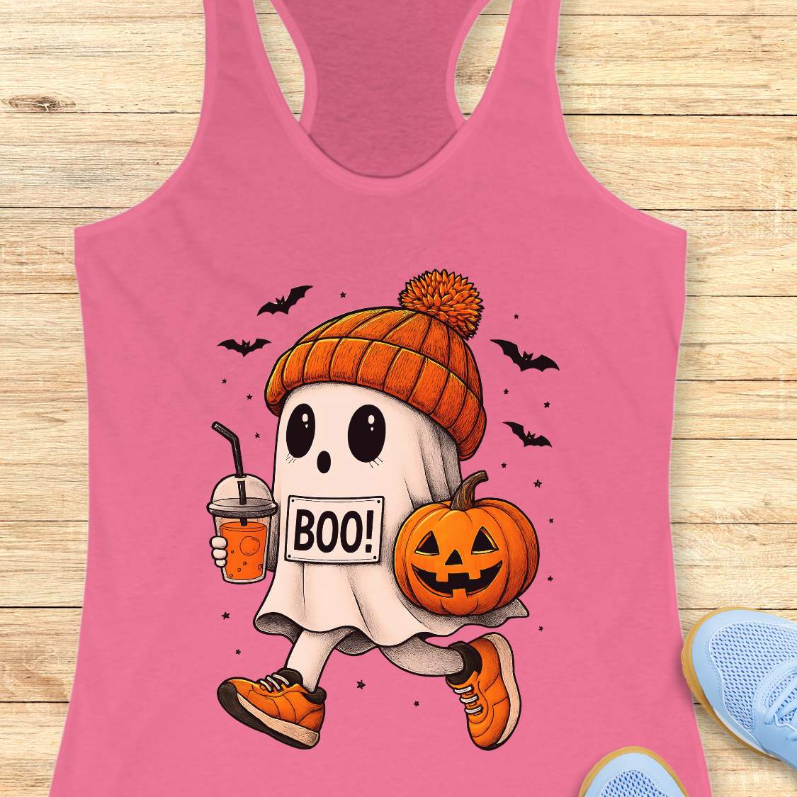 pink tank top with Halloween ghost design on a wooden surface