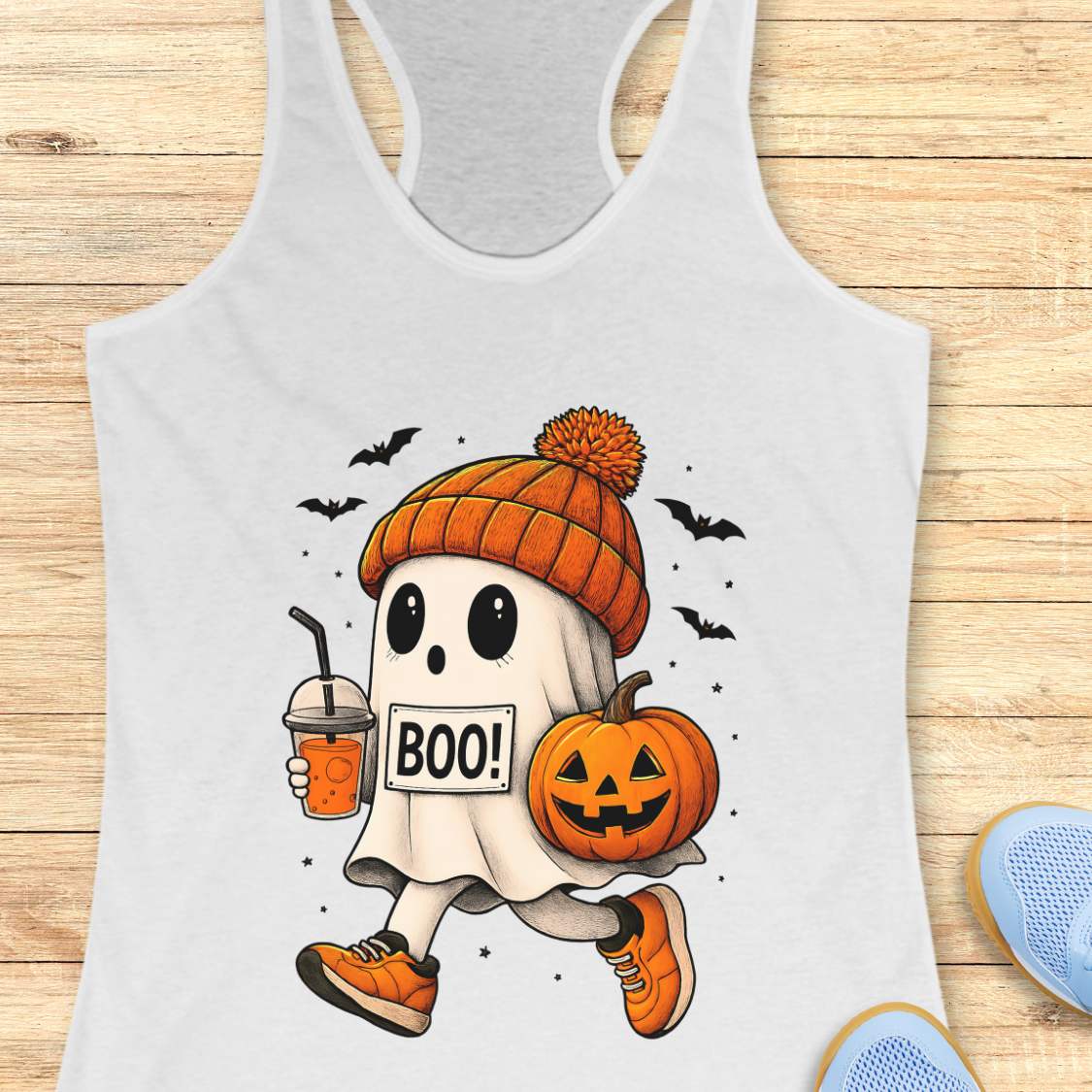 white tank top with Halloween ghost design on a wooden surface