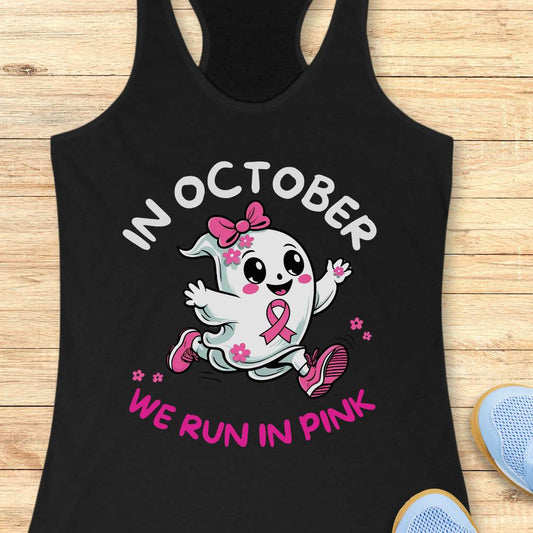 black tank top with a cartoon ghost and pink ribbon design with the text - 'in October we run in pink', on a wooden surface.