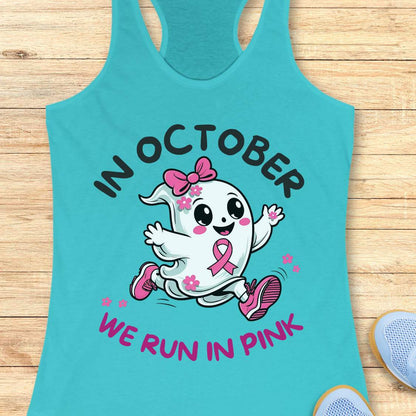 blue tank top with a cartoon ghost and pink ribbon design with the text - 'in October we run in pink', on a wooden surface.