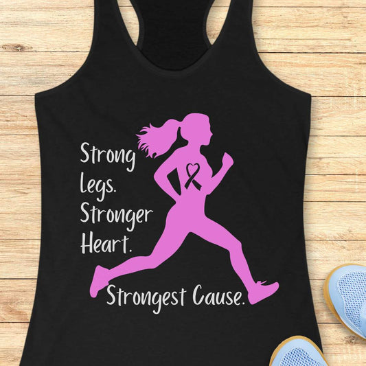 Black tank top with pink running woman graphic and text on a wooden surface with sneakers and earphones.
