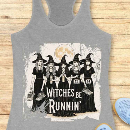 Graphic print of five cartoon witches in black dresses and pointy hats holding running shoes and water bottles, wearing race bibs 2017, 25, and 24, against a full moon with the text WITCHES BE RUNNIN