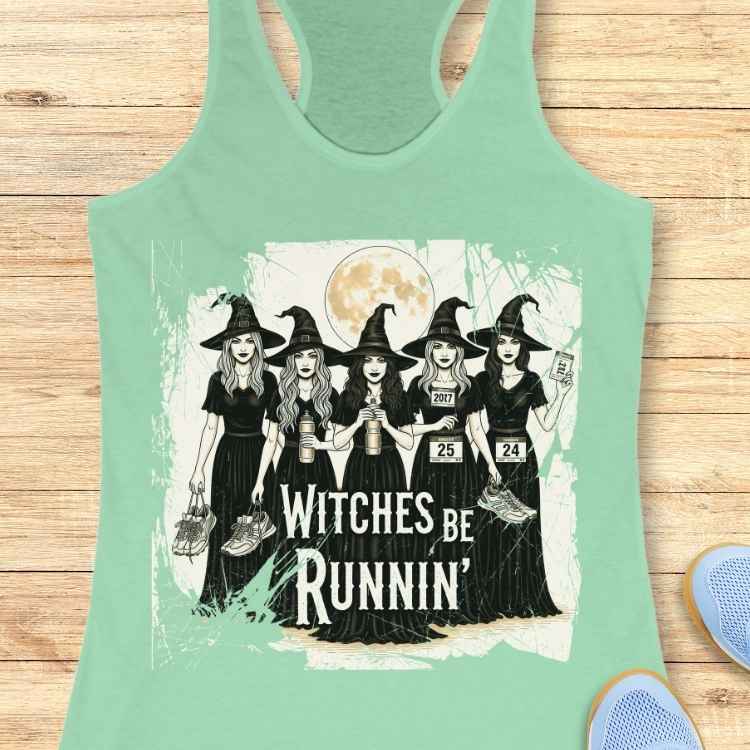Graphic design on a mint green tank top depicting five cartoon witches in black dresses and pointy hats under a full moon, holding running shoes and water bottles with race bibs, above the text "WITCHES BE RUNNIN'"