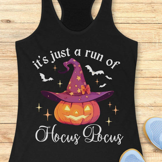 Black tank top with Halloween design featuring a pumpkin and witch hat on a wooden surface.