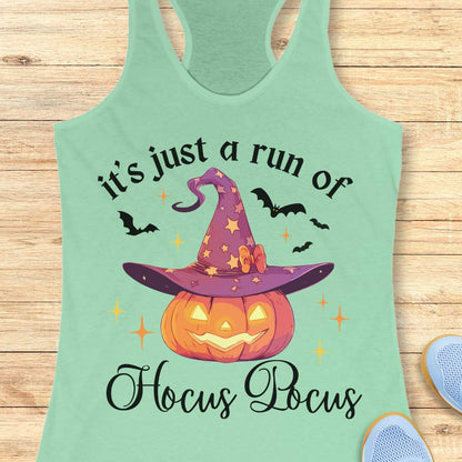 mint tank top with Halloween design featuring a pumpkin and witch hat on a wooden surface.