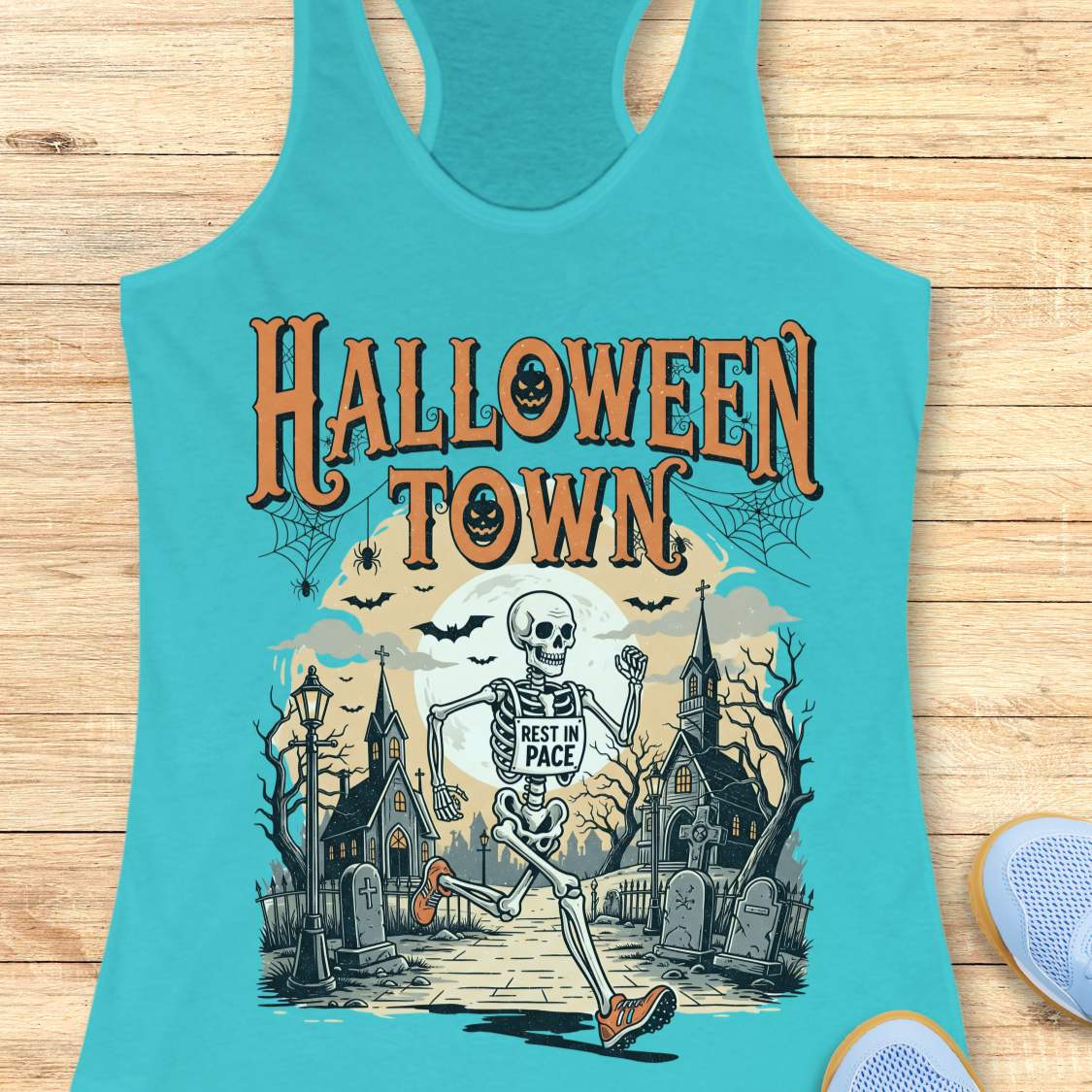 blue tank top with Halloween-themed design and a text ' Halloween town', on a wooden surface