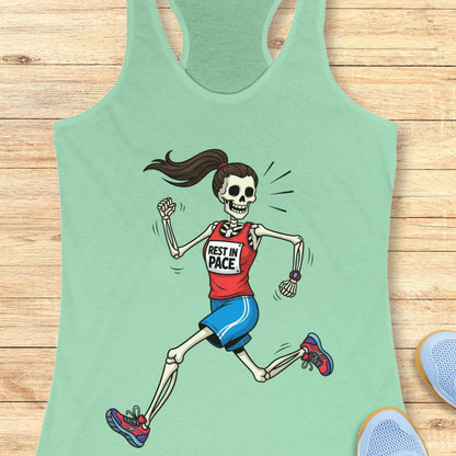 Graphic design on a mint tank top featuring a female skeleton with a ponytail running in a red 'REST IN PACE' top, blue shorts, colorful athletic shoes, and a fitness watch, laid flat on a light wood surface with white earbuds and light blue sneakers