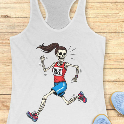 Graphic design on a white tank top featuring a female skeleton with a ponytail running in a red 'REST IN PACE' top, blue shorts, colorful athletic shoes, and a fitness watch, laid flat on a light wood surface with white earbuds and light blue sneakers