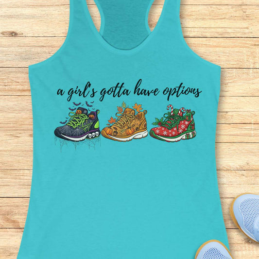 blue tank top with running shoes designs and text 'a girl's gotta have options',  on a wooden surface