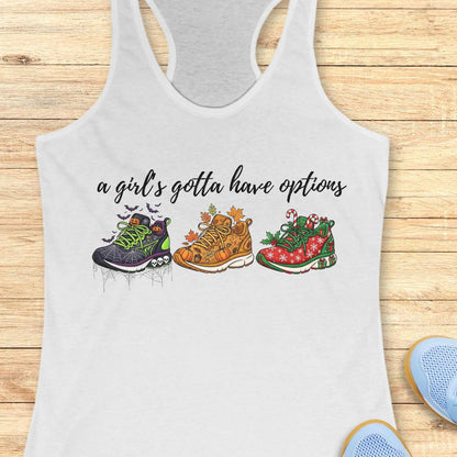 white tank top with running shoes designs and text 'a girl's gotta have options',  on a wooden surface