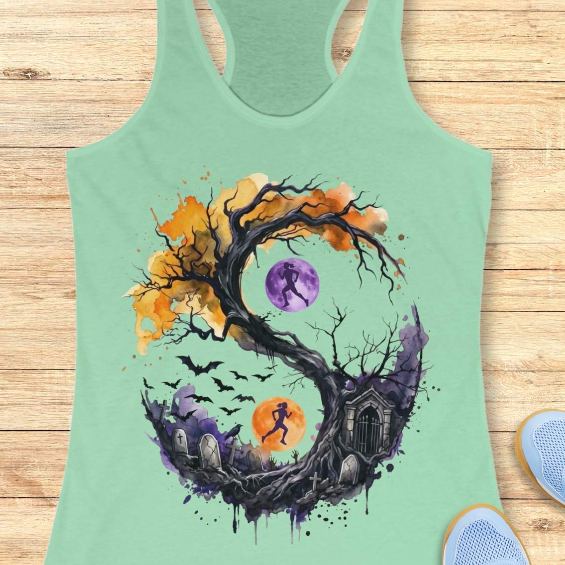 mint tank top with Halloween ying and yang graphic design , on a wooden surface
