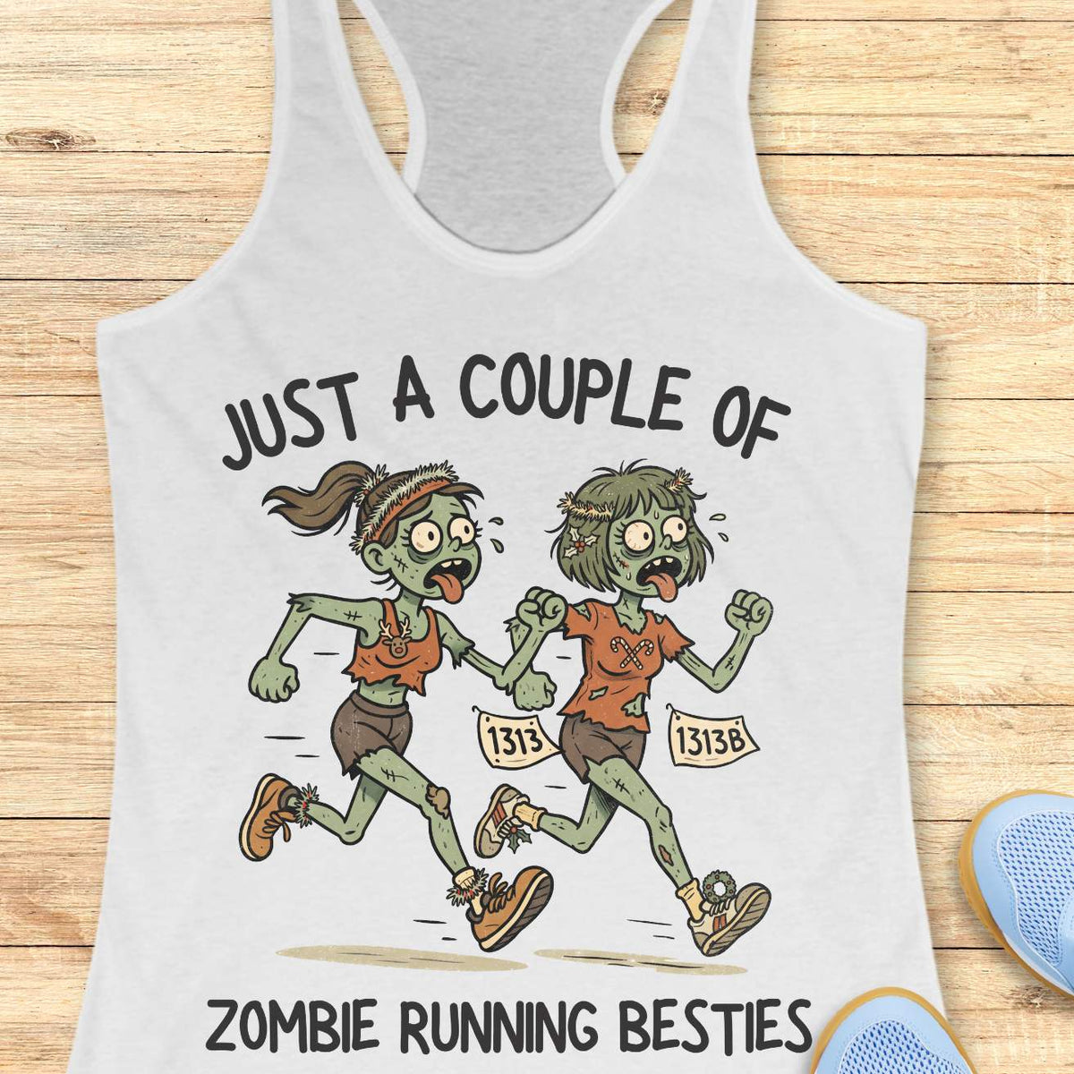 white racerback tank top featuring the phrase “JUST A COUPLE OF” above two cartoon zombie runners and “ZOMBIE RUNNING BESTIES” below. The two zombie friends are running side by side wearing race bibs numbered 1313 and 1313B, with tattered running clothes, messy hair, and humorous zombie details. The playful Halloween-themed design combines friendship and running with a spooky, fun aesthetic perfect for runners who love Halloween.