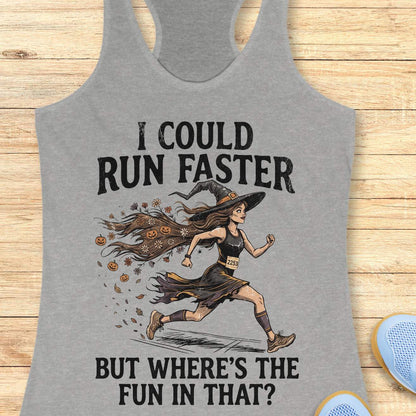 grey racerback tank top featuring the humorous Halloween running quote, “I COULD RUN FASTER BUT WHERE’S THE FUN IN THAT?” The design shows a witch runner wearing a pointed hat, flowing tattered dress, and race bib number 2253, sprinting forward. Her long hair trails behind her, filled with autumn leaves, flowers, and small jack-o'-lanterns, creating a magical motion effect. The artwork combines running motivation with spooky Halloween charm, making it perfect for runners who prefer enjoying the journey over