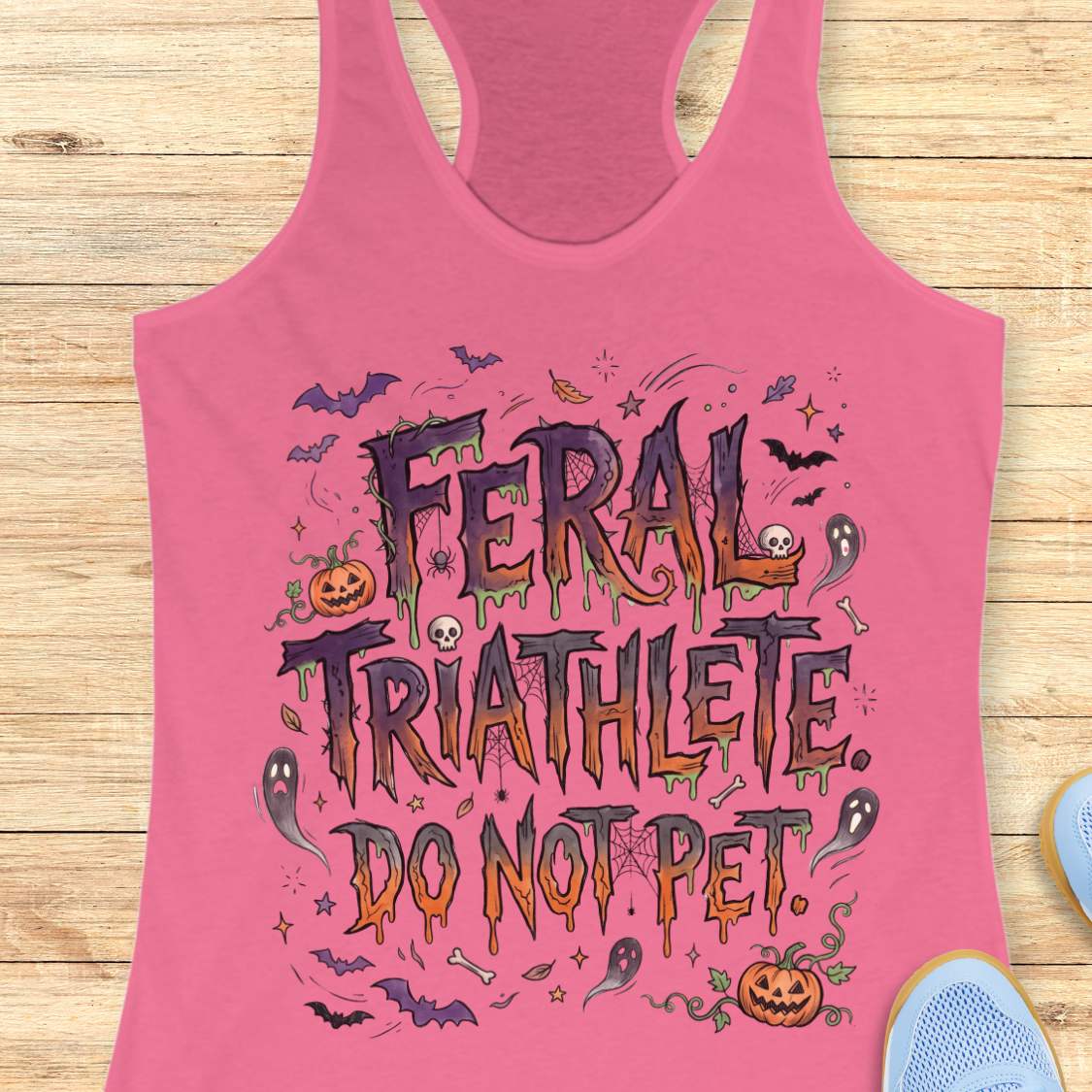 Funny Halloween running pink tank top featuring the slogan “Feral Triathlete Do Not Pet” in spooky dripping typography surrounded by bats, ghosts, pumpkins, spider webs, and Halloween elements. Humorous athletic apparel for women runners, triathletes, marathoners, and Halloween race participants.