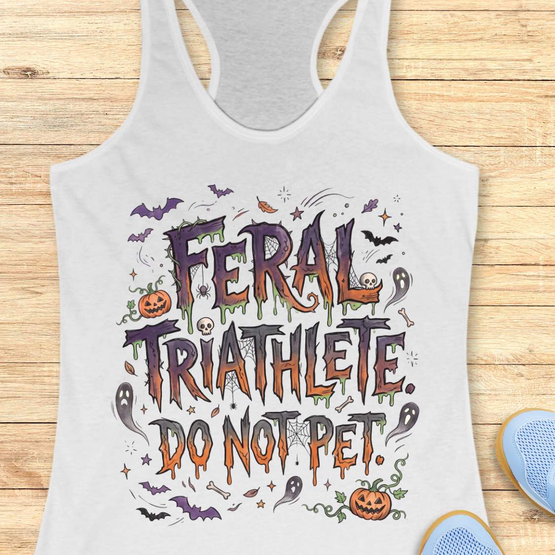 Funny Halloween running white tank top featuring the slogan “Feral Triathlete Do Not Pet” in spooky dripping typography surrounded by bats, ghosts, pumpkins, spider webs, and Halloween elements. Humorous athletic apparel for women runners, triathletes, marathoners, and Halloween race participants.