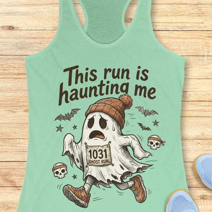 mint Halloween tank top with an image of a running ghost and text 'This run is haunting me', on a wooden surface