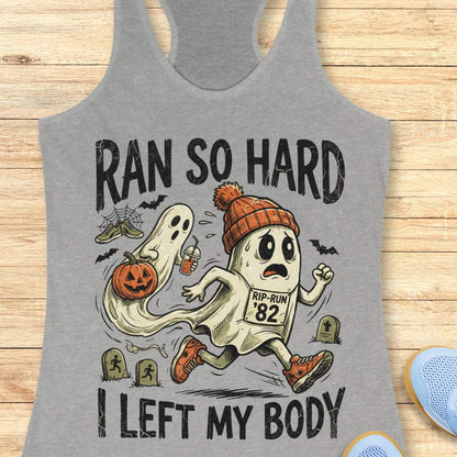 grey Halloween tank top with an image of a running ghost and text 'Ran so hard I left my body', on a wooden surface