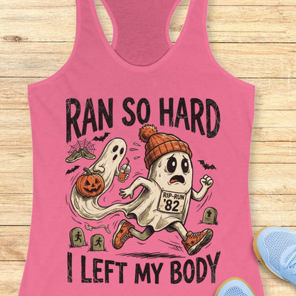 pink Halloween tank top with an image of a running ghost and text 'Ran so hard I left my body', on a wooden surface