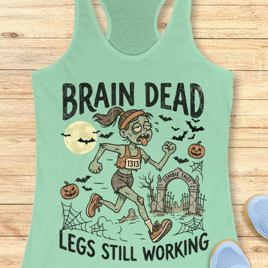 mint Halloween tank top with an image of a running zombie and text 'Brain dead legs still working', on a wooden surface