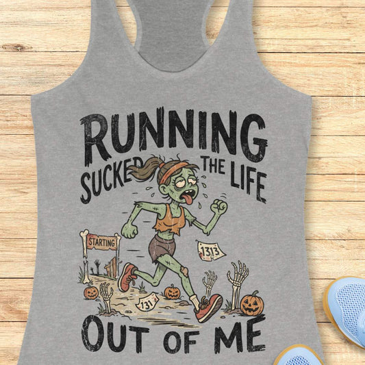 grey Halloween tank top with an image of a running zombie and text 'Running sucked the life out of me', on a wooden surface