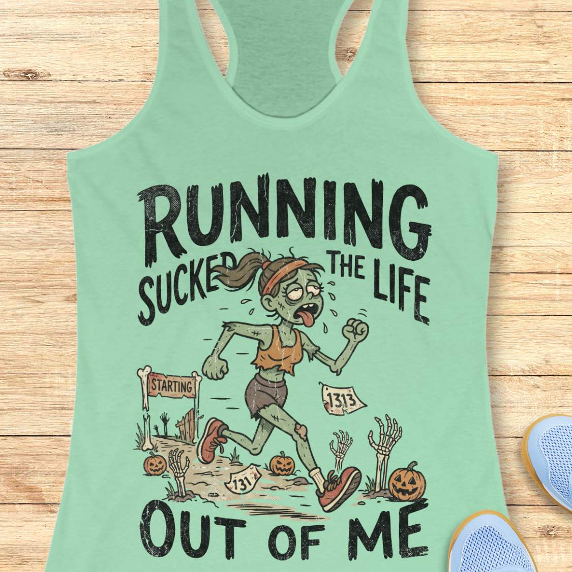 mint  Halloween tank top with an image of a running zombie and text 'Running sucked the life out of me', on a wooden surface