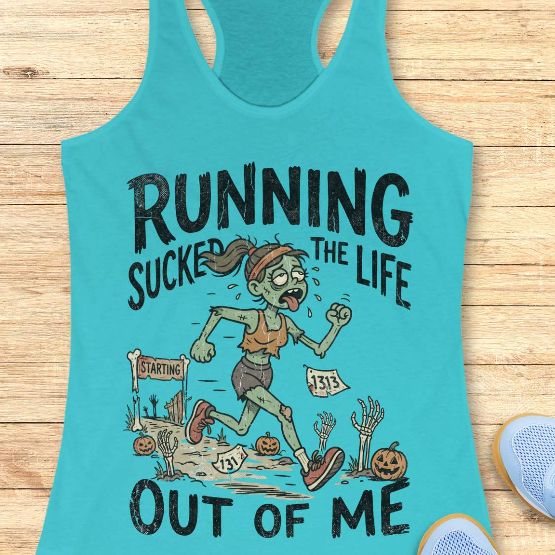 blue Halloween tank top with an image of a running zombie and text 'Running sucked the life out of me', on a wooden surface