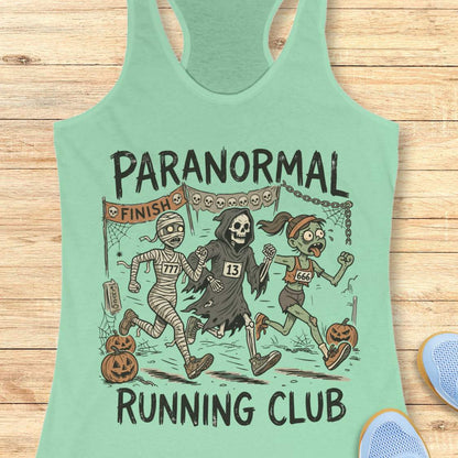 mint Halloween tank top with an image of a running zombie, mummy and reaper,  and text 'Paranormal running club', on a wooden surface