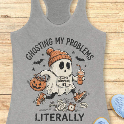 grey Halloween tank top with an image of a running ghost and text 'Ghosting my problems literally', on a wooden surface