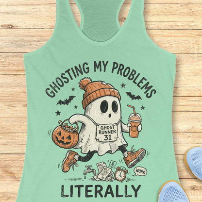mint Halloween tank top with an image of a running ghost and text 'Ghosting my problems literally', on a wooden surface
