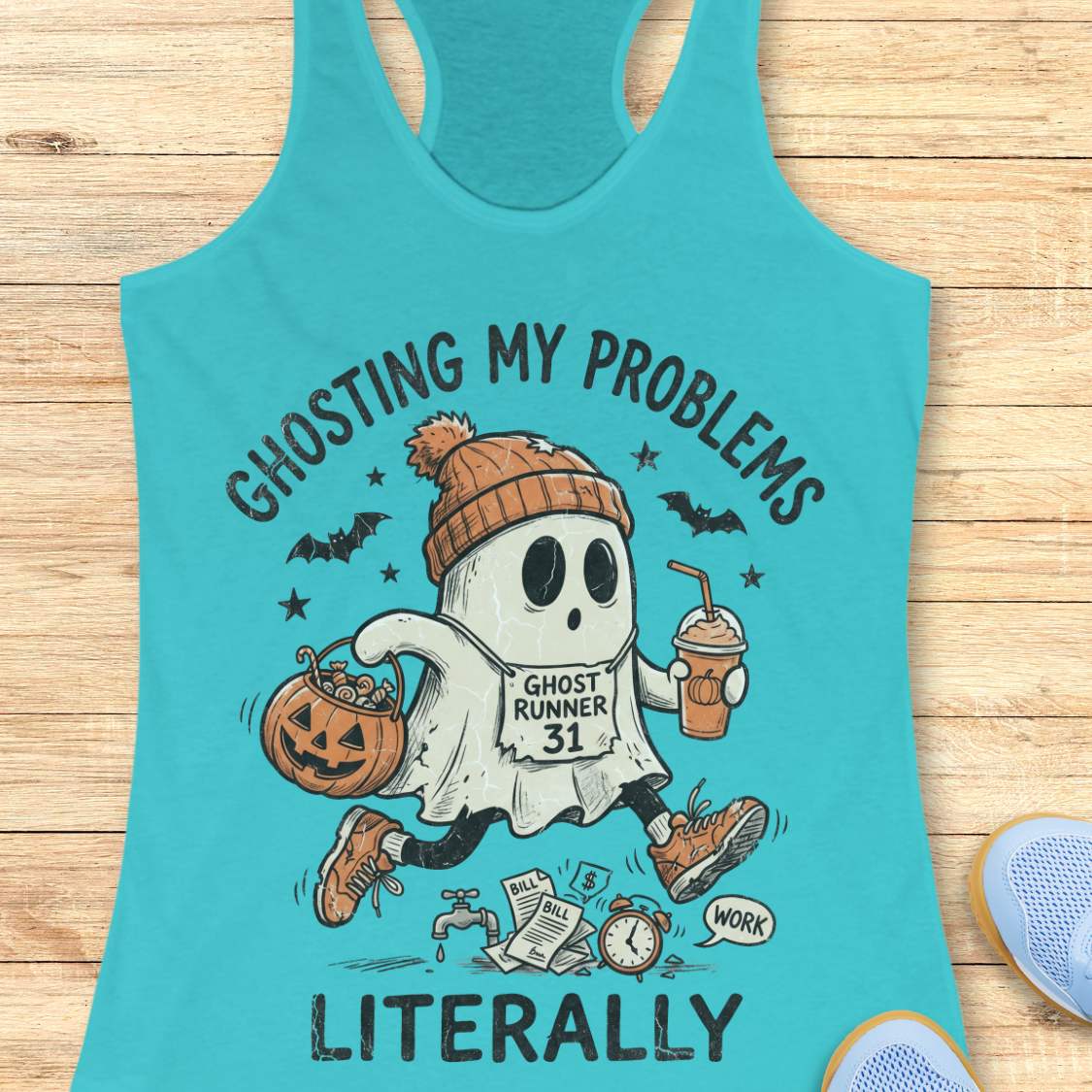 blue Halloween tank top with an image of a running ghost and text 'Ghosting my problems literally', on a wooden surface