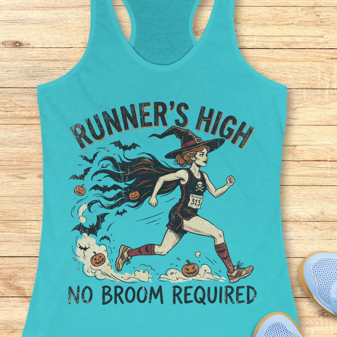 A turquoise racerback tank top laid flat on a light wood surface, featuring a Halloween-themed graphic of a witch running with pumpkins and bats, with the text 'RUNNER'S HIGH' and 'NO BROOM REQUIRED'.
