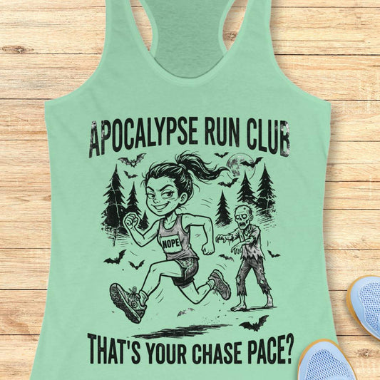A mint green racerback tank top laid flat on a light wood background, featuring a black graphic of a woman running with a zombie and the text 'APOCALYPSE RUN CLUB' and 'THAT'S YOUR CHASE PACE?'.