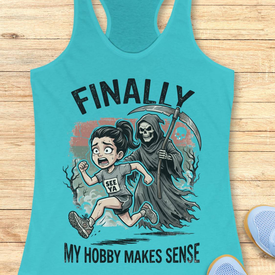A turquoise racerback tank top laid flat on a light wood surface, featuring a graphic print of a girl running alongside a grim reaper with the text 'FINALLY MY HOBBY MAKES SENSE'.