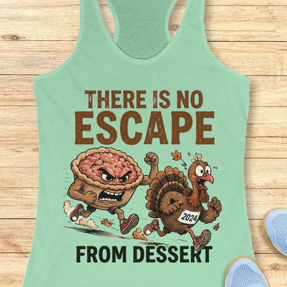 A mint green racerback tank top laid flat on a light wood background, featuring a cartoon graphic of an angry pie and a turkey running away, with the text 'THERE IS NO ESCAPE FROM DESSEKT'.