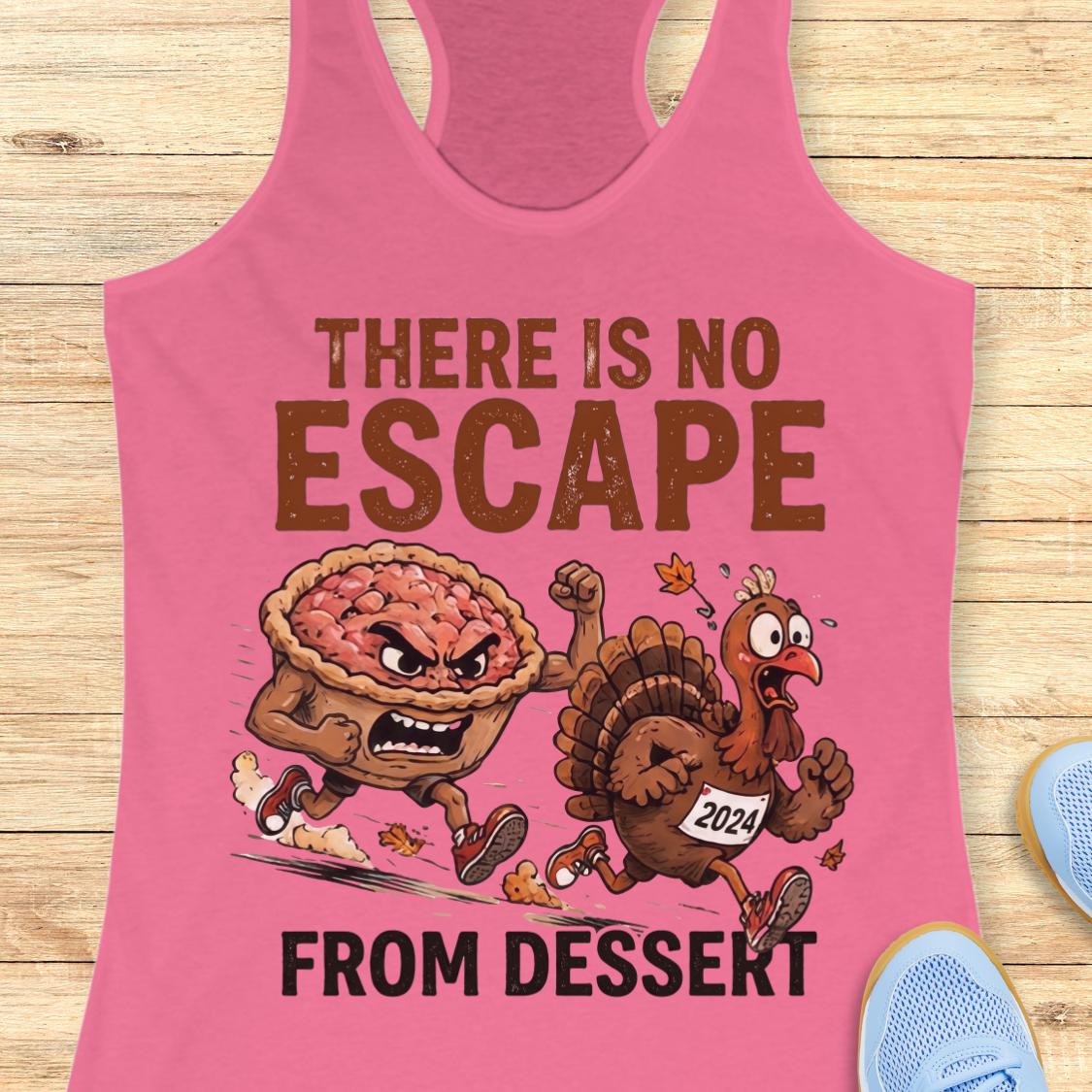 A pink racerback tank top laid flat on a light wood surface, featuring a Thanksgiving-themed graphic with the text 'THERE IS NO ESCAPE FROM DESSEKT' and cartoon characters running with a pie and a turkey wearing a 2024 bib.