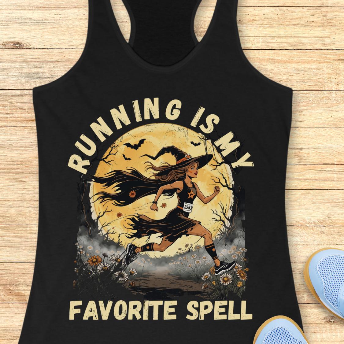A black racerback tank top laid flat on a light wood surface, featuring a large graphic print of a witch running in front of a full moon with the text 'RUNNING IS MY FAVORITE SPELL.' Part of a blue shoe is visible at the bottom right as a styling prop.