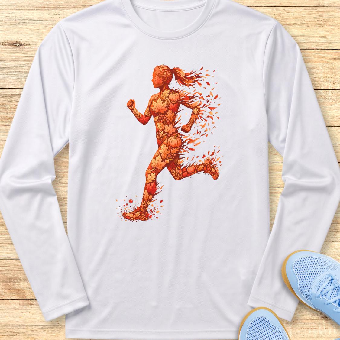 A white long-sleeve t-shirt with a graphic of a running woman made of orange and red splatters, displayed flat on a light wood background with blue sneakers partially visible in the corner.