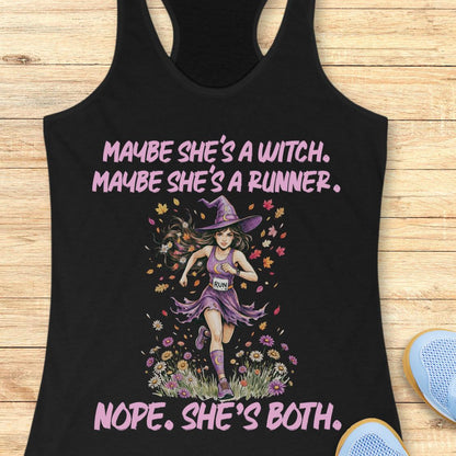 A black racerback tank top laid flat on a light wood background, featuring a graphic of a witch running with flowers and the text 'MAYBE SHE'S A WITCH. MAYBE SHE'S A RUNNER.