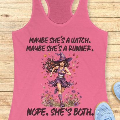 A pink racerback tank top laid flat on a light wood surface, featuring a graphic of a witch running with the text 'MAYBE SHE'S A WITCH. MAYBE SHE'S A RUNNER.
