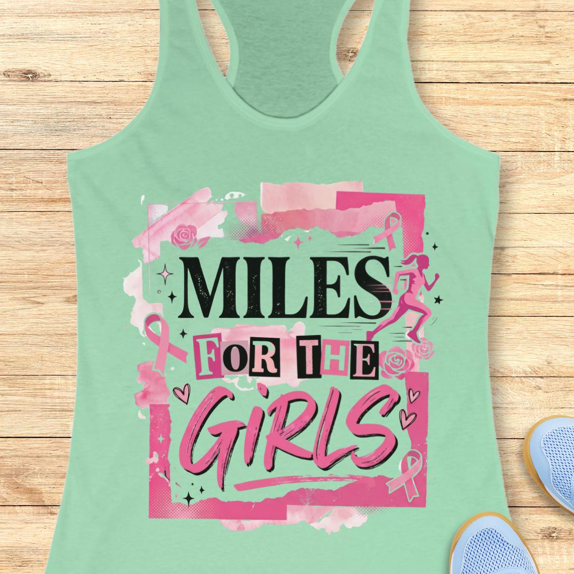 A mint green racerback tank top with a pink and black graphic that reads 'MILES FOR THE GIRLS' on a light wood background, with partial blue sneakers visible at the bottom right.